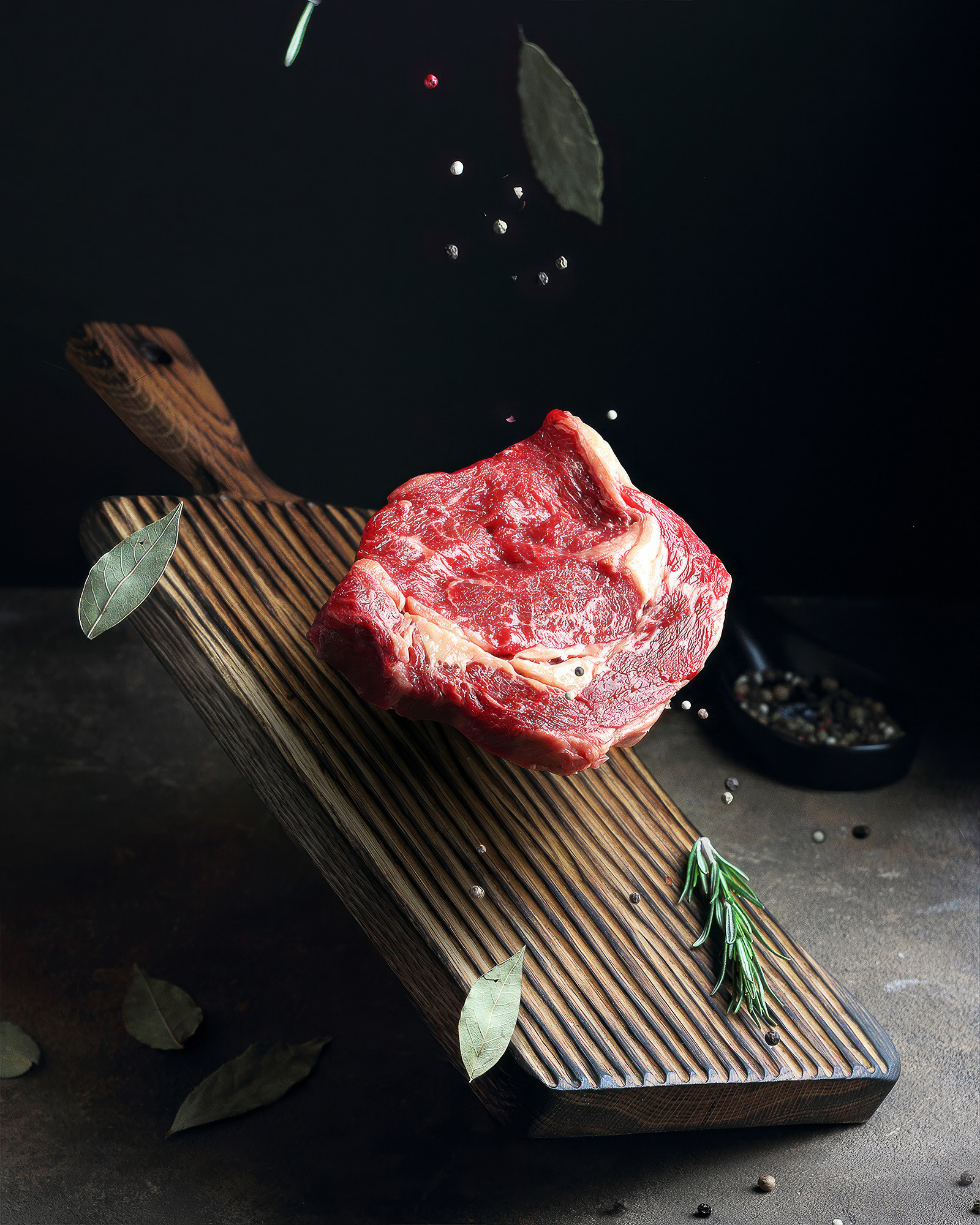 фуд-фото левитации мяса, стейк рибай, на темном фоне 