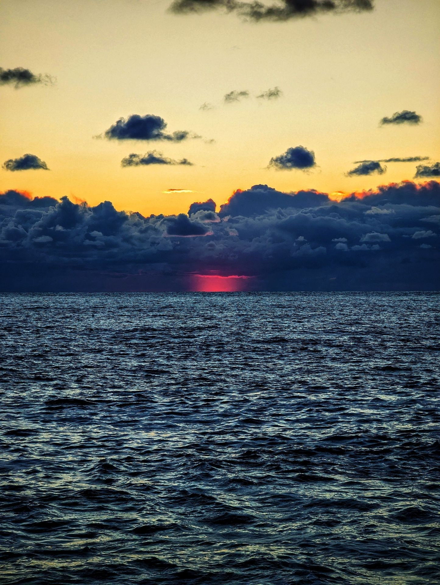 Закат над морем: теплые оттенки солнца отражаются в воде