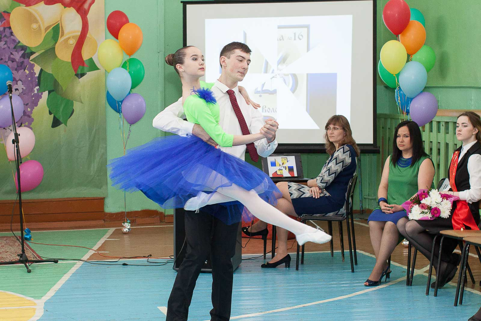 Выпускник и выпускница 11 класса танцуют балет на последнем звонке.