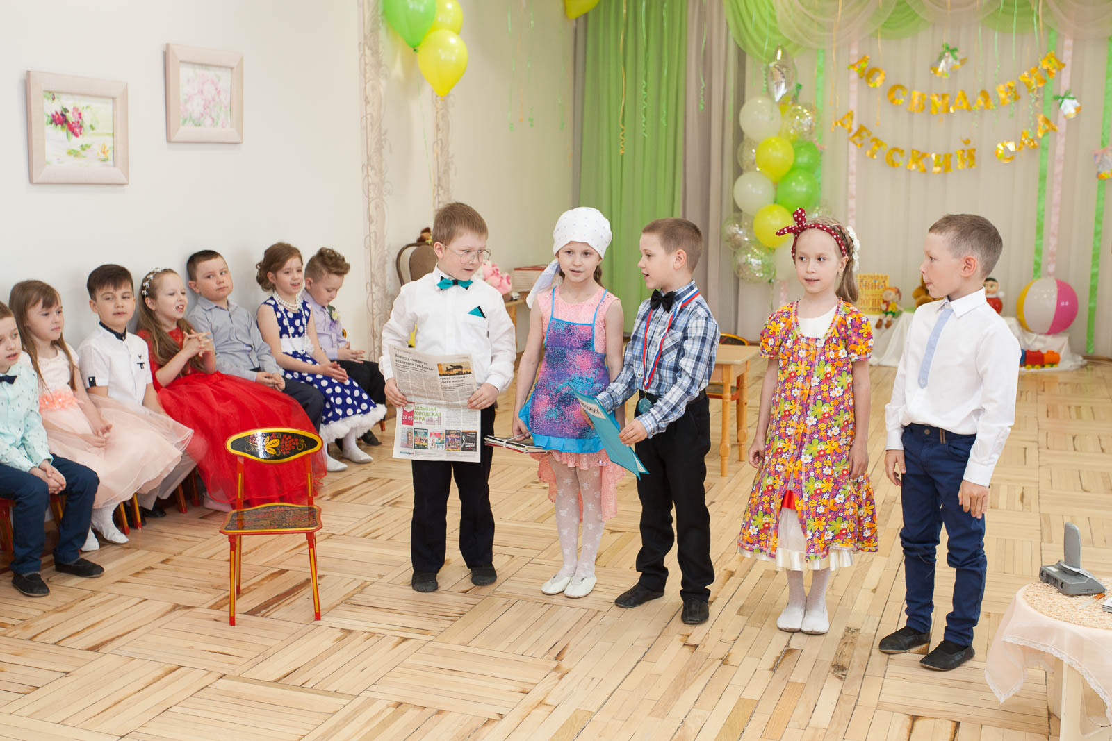 Выпускники детского сада играют сценку на выпускном утреннике в детском саду.
