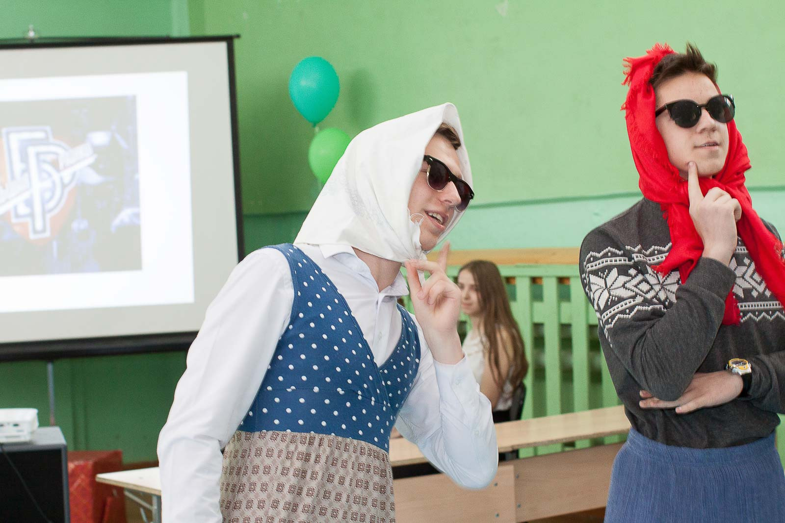 Два мальчика переодетые в бабушек в темных очках выступают на последнем звонке.