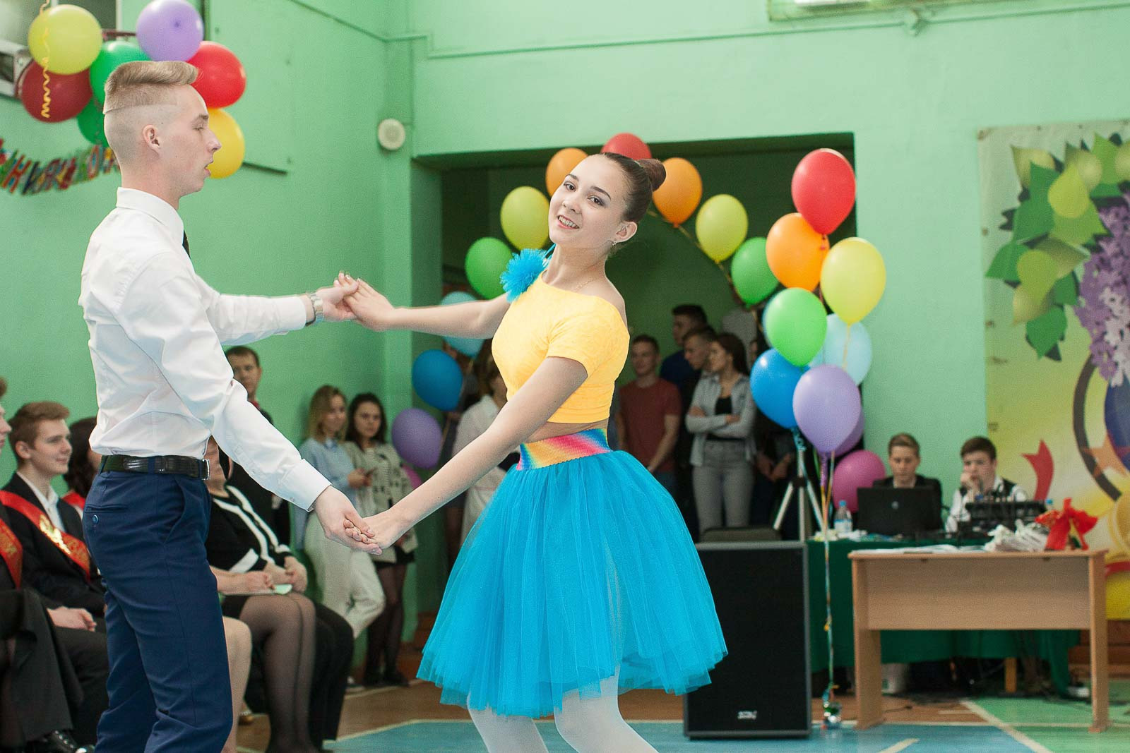 Выпускник и выпускница 11 класса танцуют вальс на последнем звонке.