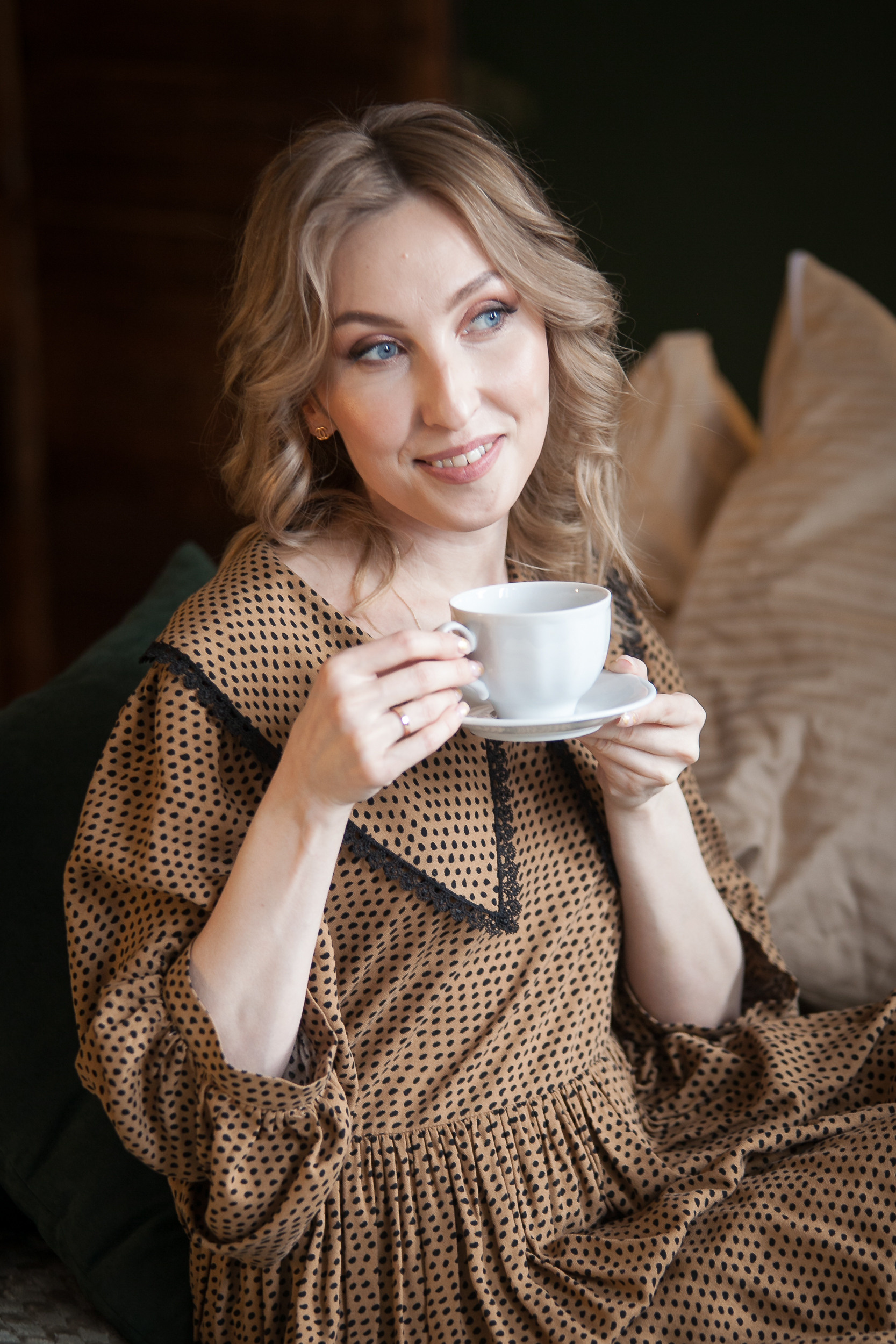 Студийный портрет девушки с кружкой в руках при естественном освещении в интерьерной фотостудии.