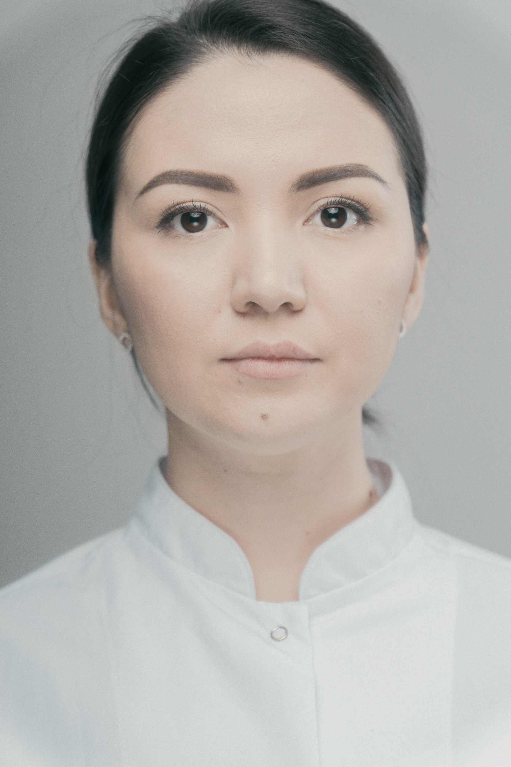 Светлый портрет женщины в белой одежде на ровном фоне — чистая и аккуратная студийная портретная съёмка.