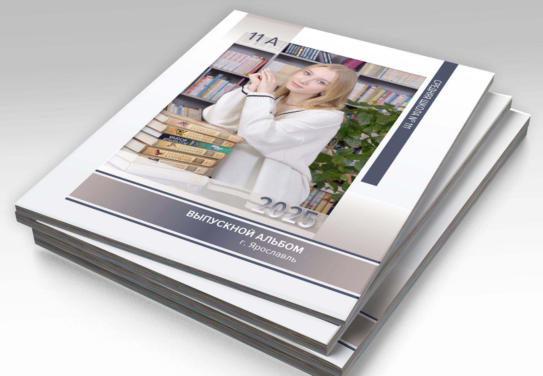 Стопка альбомов выпускника средней школы, на титульной стороне портрет выпускницы.