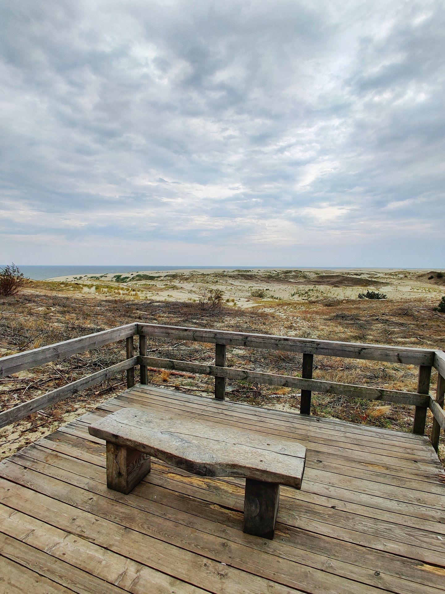 Деревянная смотровая площадка с лавкой и видом на дюны и Балтийское море