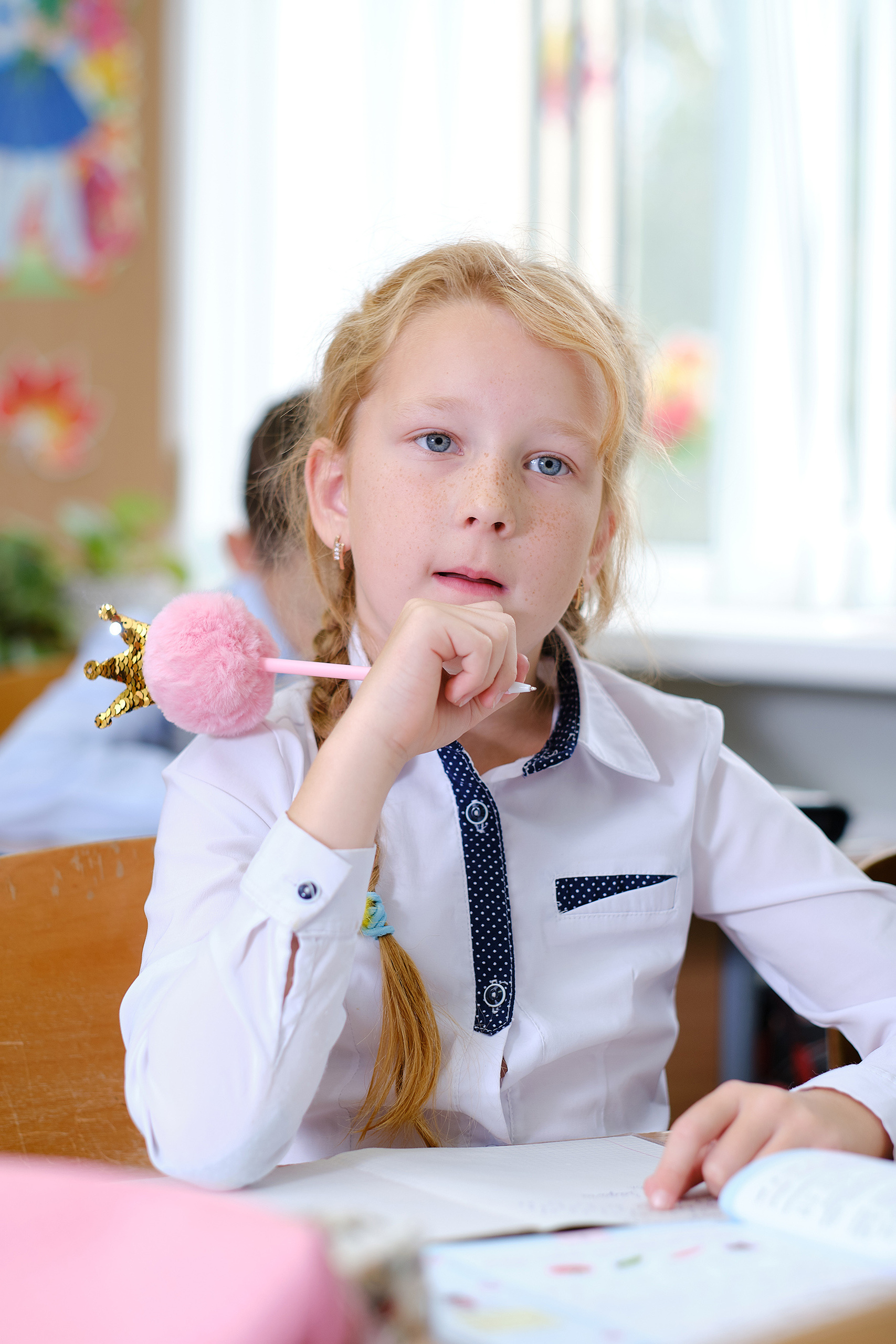 Портрет девочки в классе с ручкой в руке