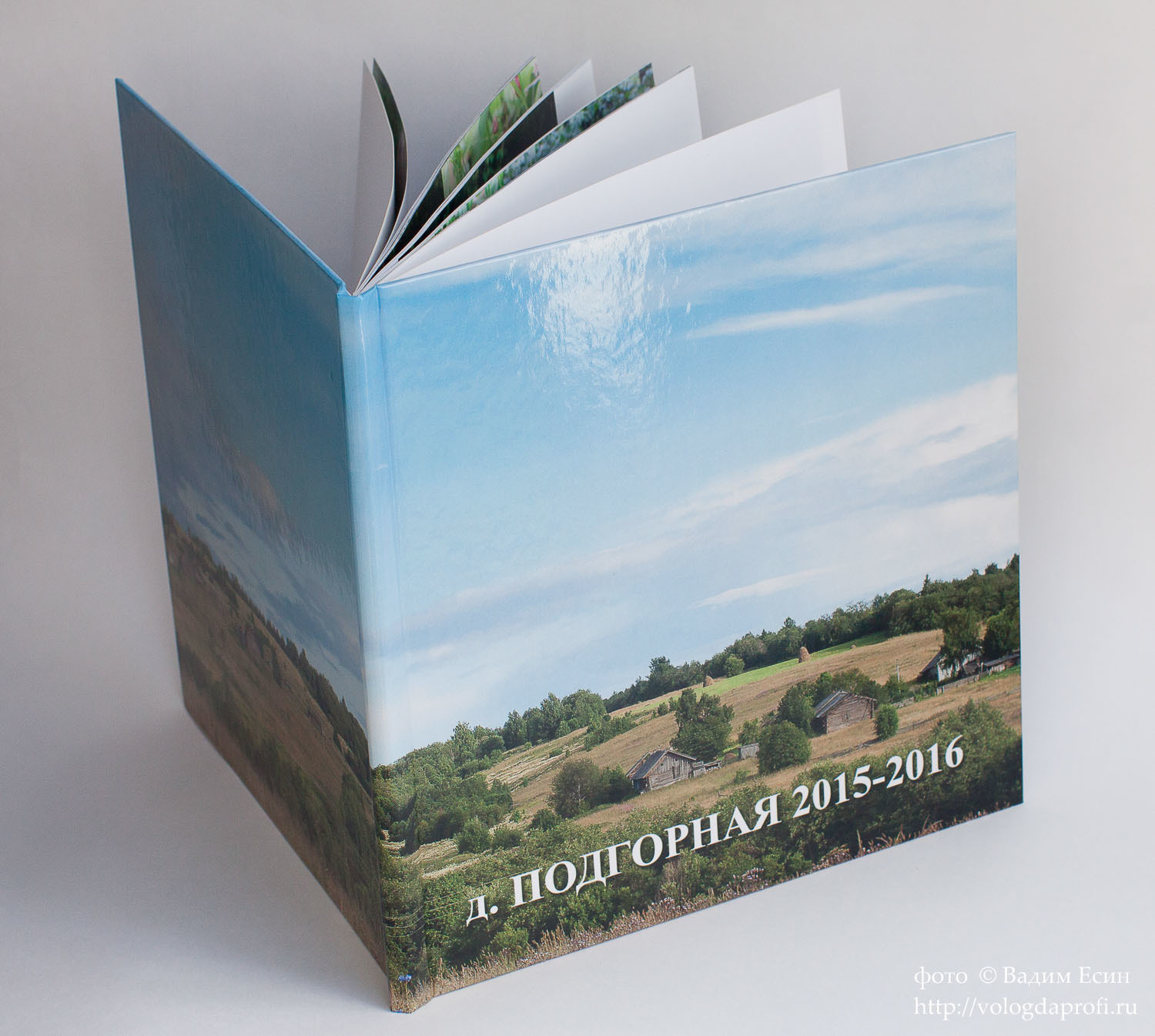 Обложка квадратной семейной фотокниги с изображением деревни.