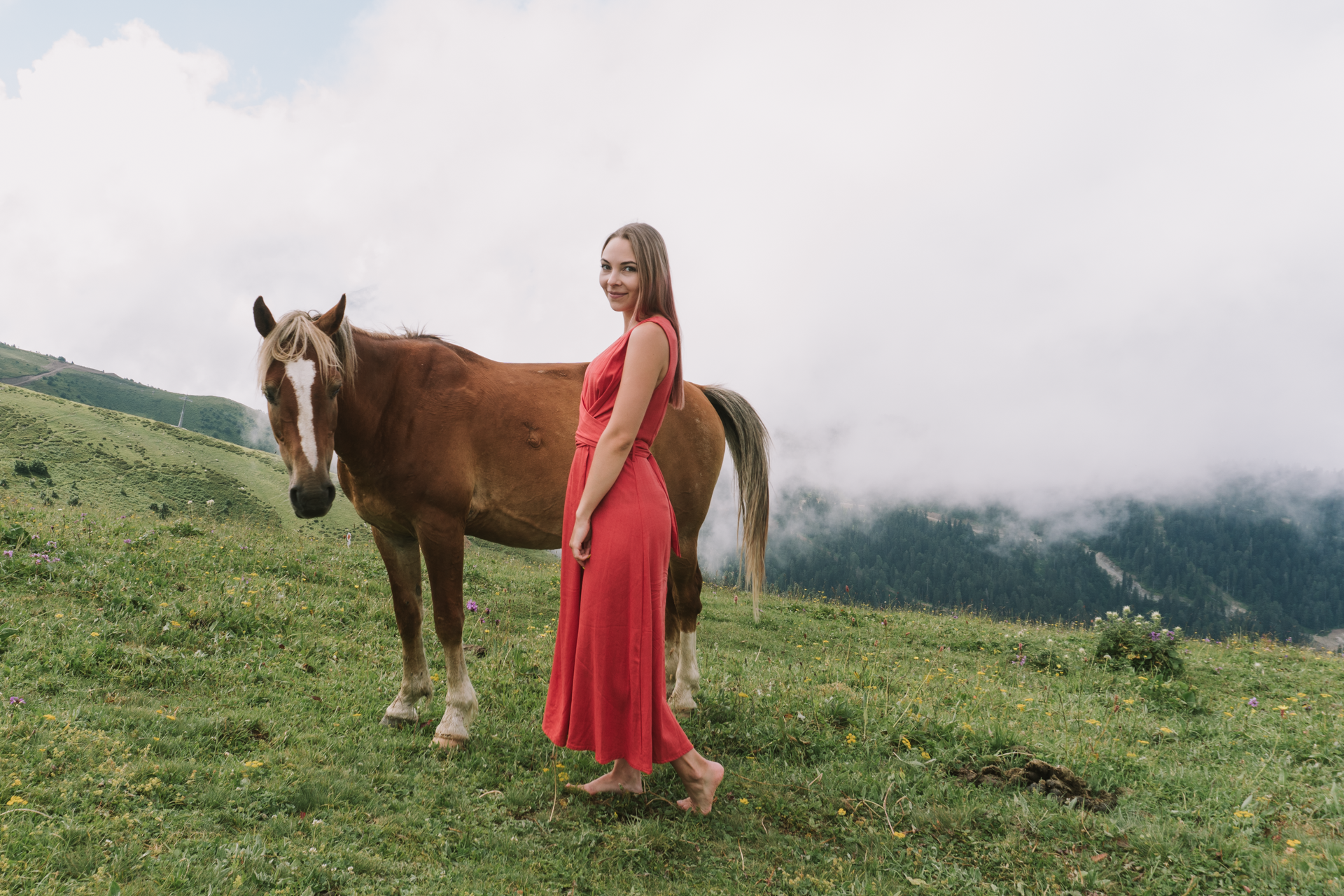 Общий кадр девушки на фоне гор и коня