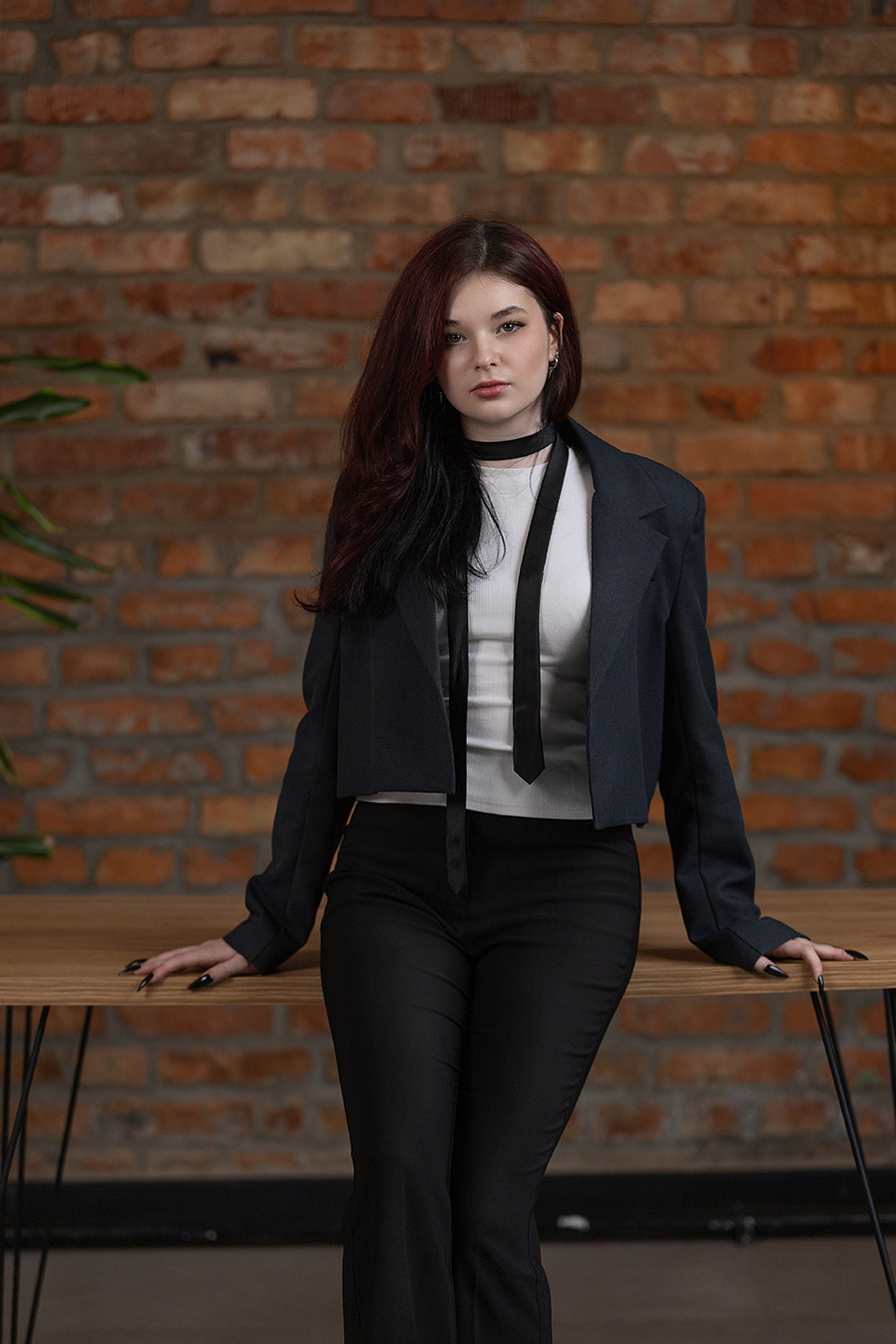 Портрет выпускницы 11 класса в фотостудии на фоне кирпичной стены