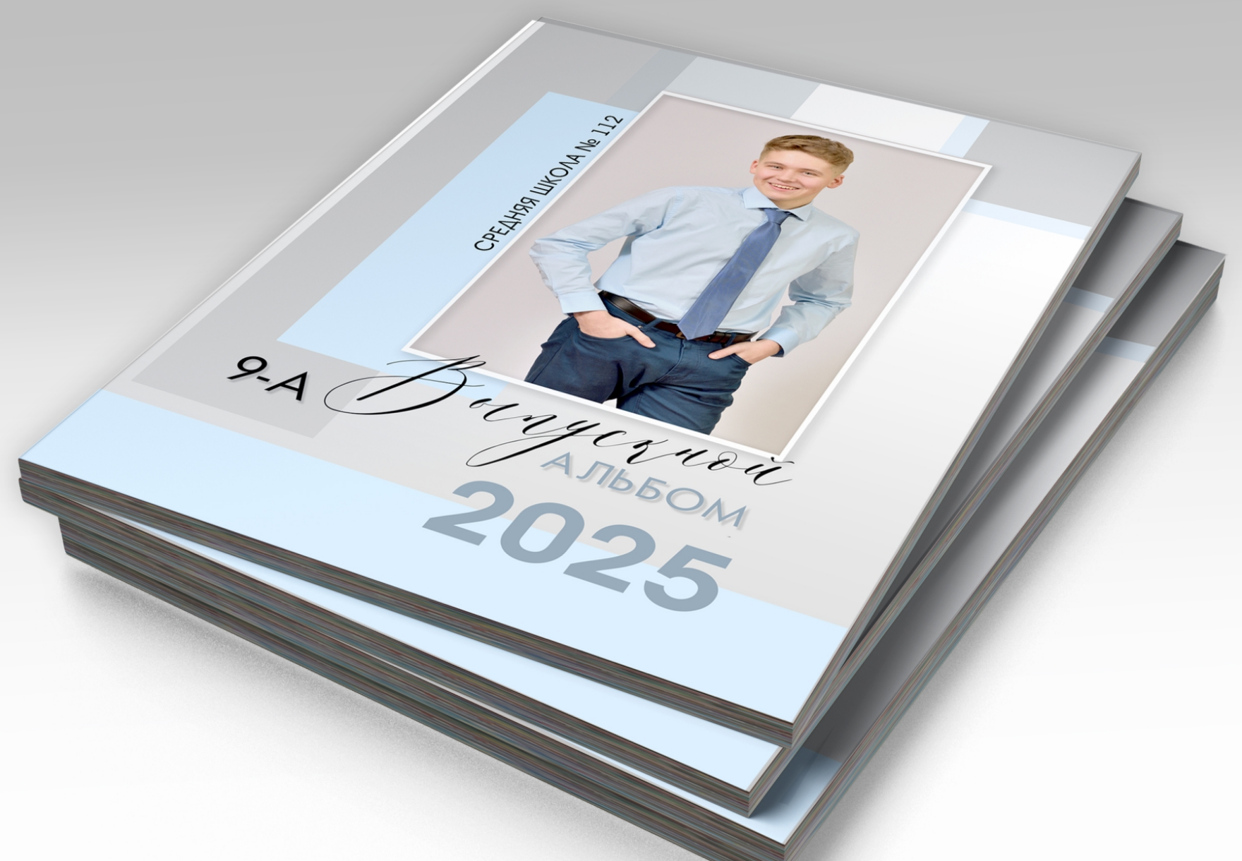 Стопка альбомов выпускника средней школы, на титульной стороне портрет выпускника.