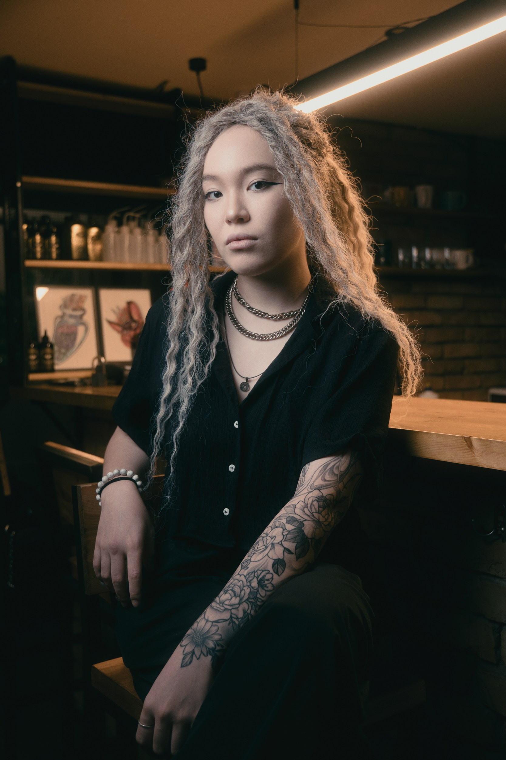 Интерьерный портрет женщины с татуировками в баре — атмосферная портретная съёмка в заведении Астаны
