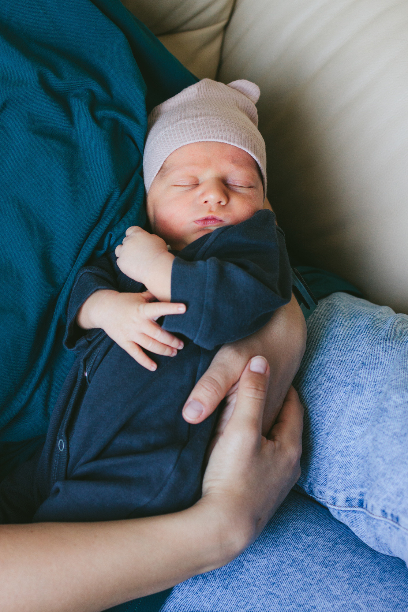 Семейная фотосессия новорожденного дома в Симферополе. Новорожденный спит на руках у матери.