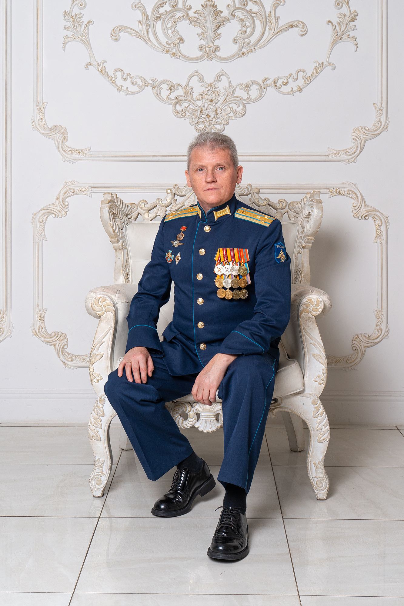 Офицер в форме сидит в кресле. Офицер-воспитатель кадетского класса.