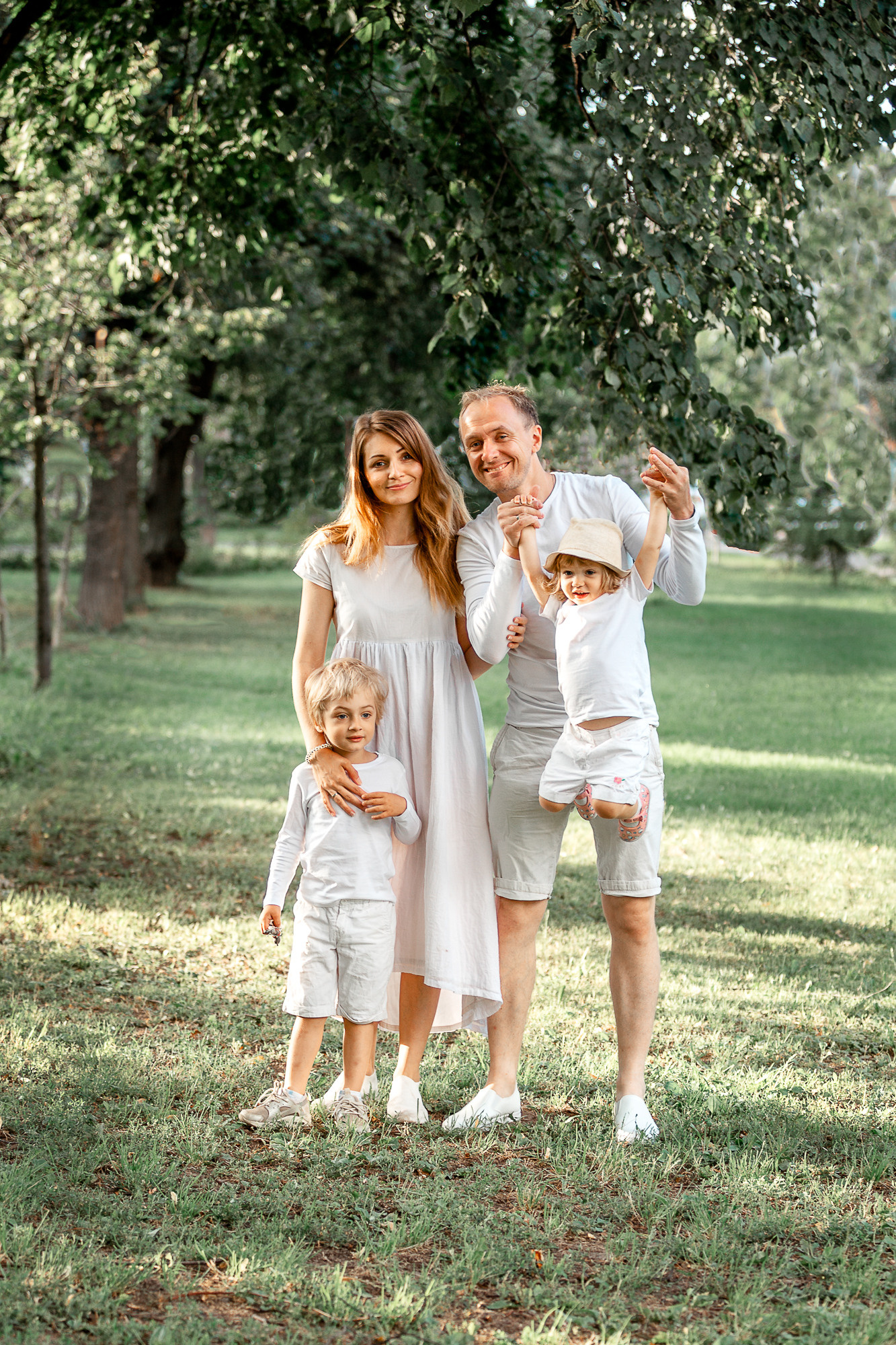 Семья с детьми в белой одежде, счастливые, летняя фотография.