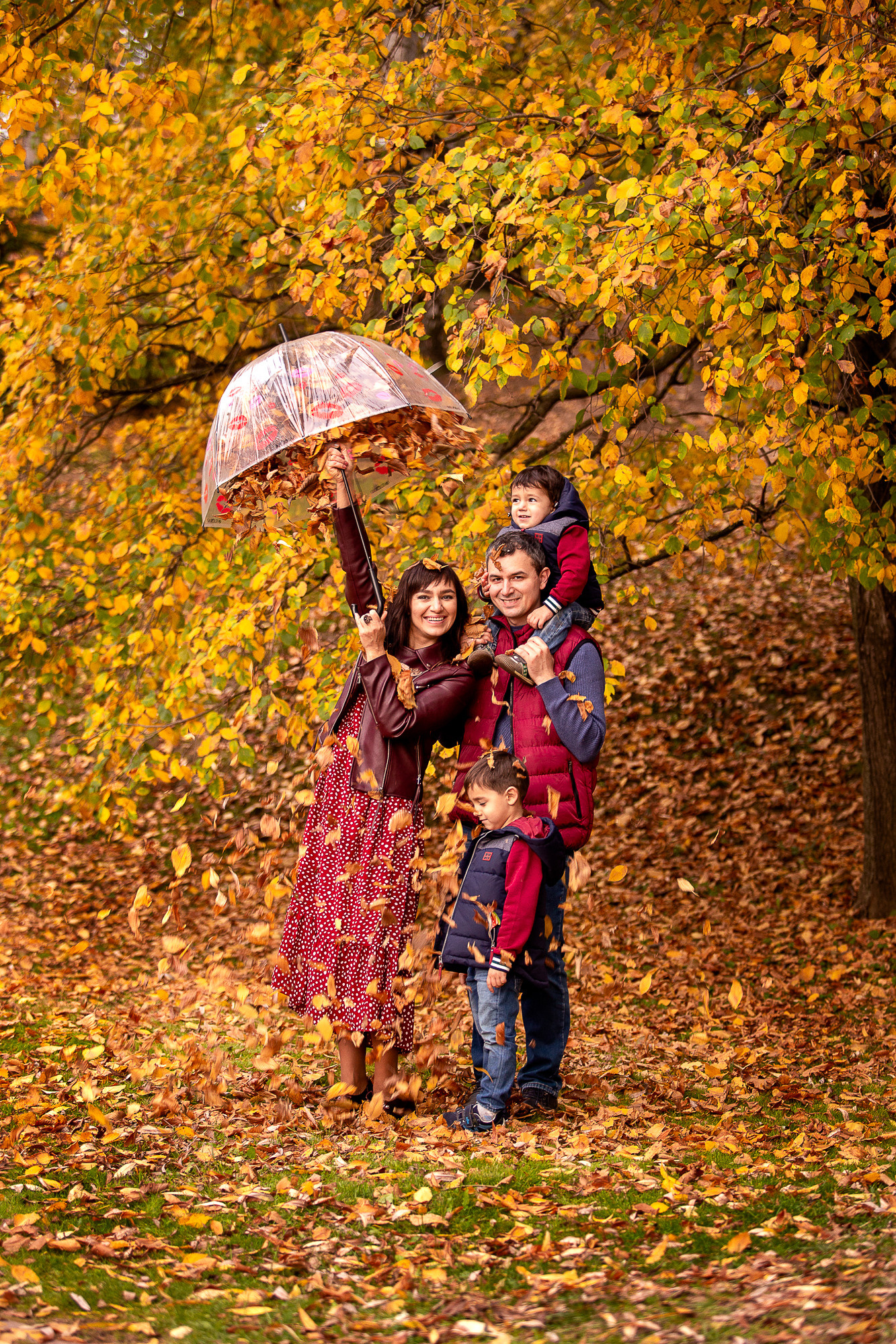 Осенняя семейная фотография с летящими листьями из зонтика.
