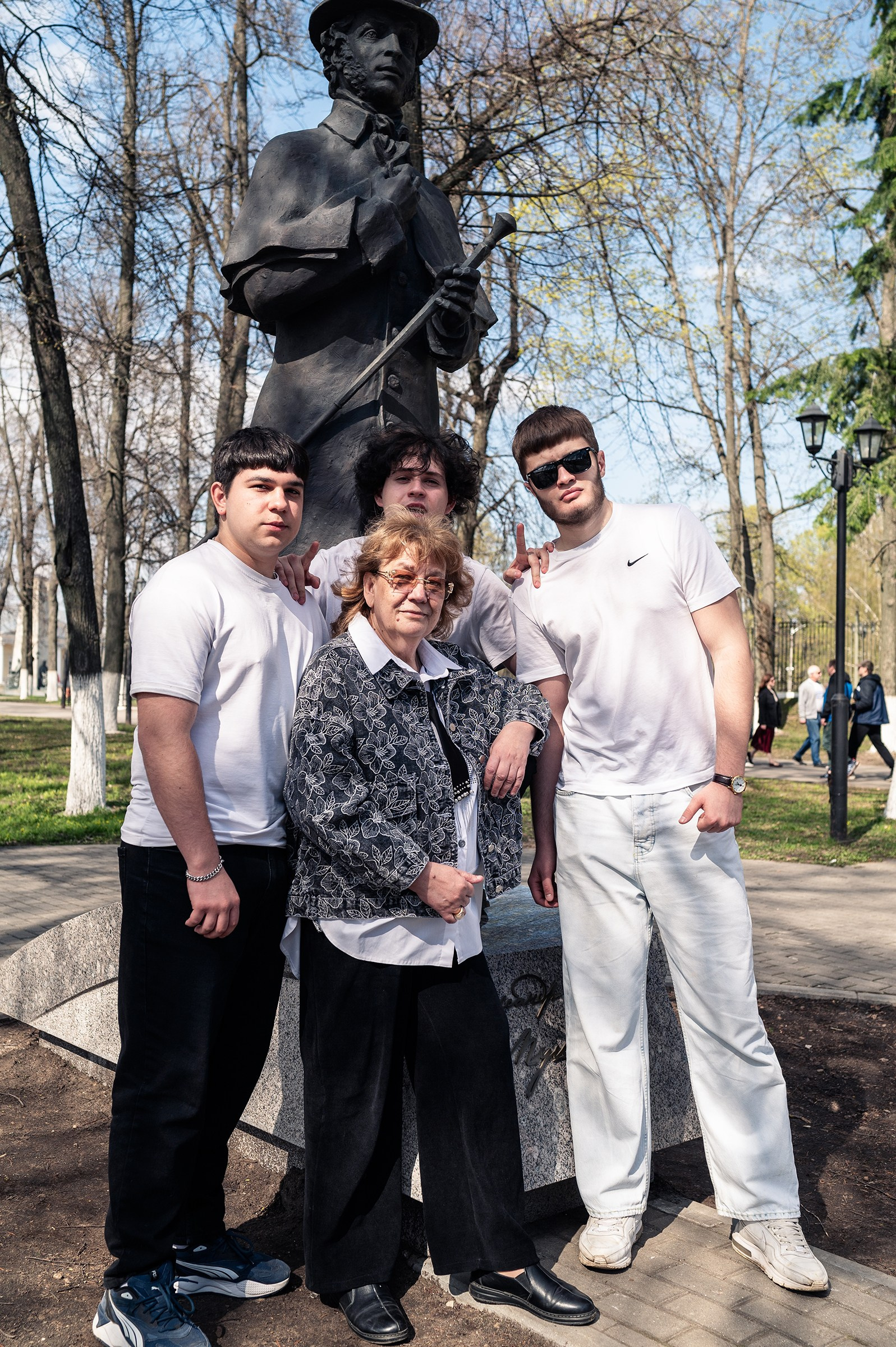 Фотосессия для выпускного альбома. Классный руководитель позирует с учениками на фоне памятника Пушкину.