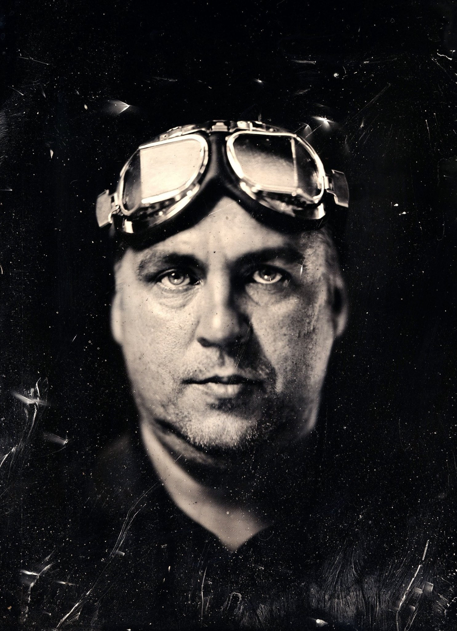 Черно-белая фотография мужчины на темном фоне в стиле стимпанк.