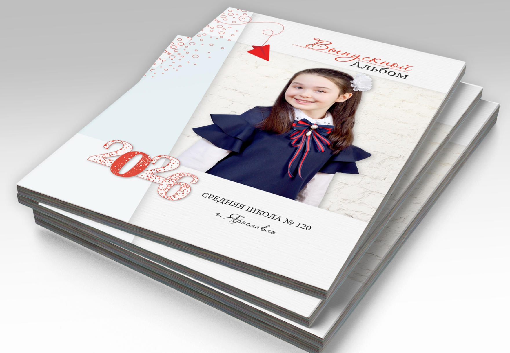 Стопка альбомов выпускника начальной школы, на титульной стороне портрет выпускницы.