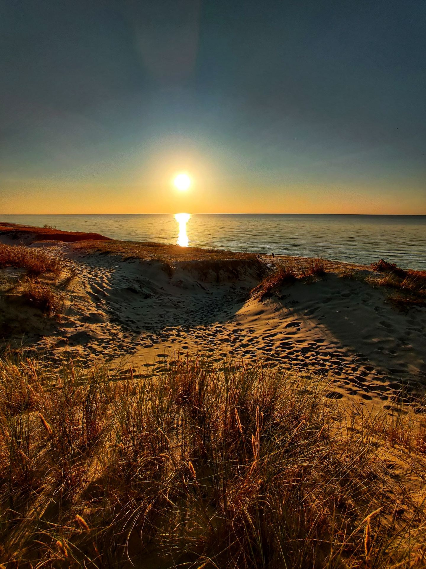 Закат над Балтийским морем с дюнами и песчаной тропой на переднем плане