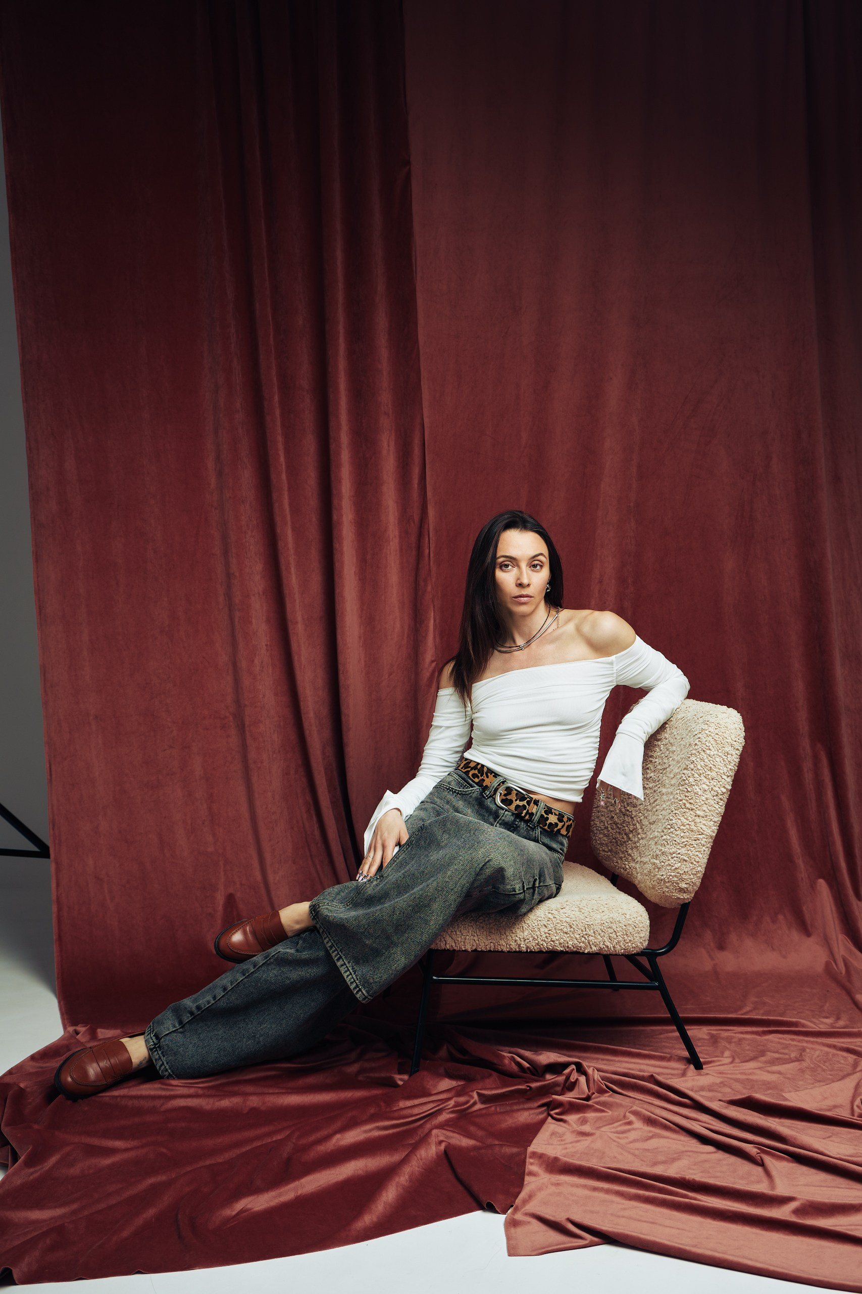 Студийный портрет на красном тканевом фоне