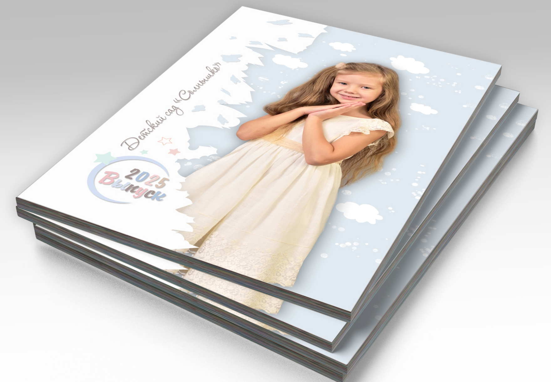 Стопка выпускных альбомов детского сада, на титульной стороне портрет выпускницы.